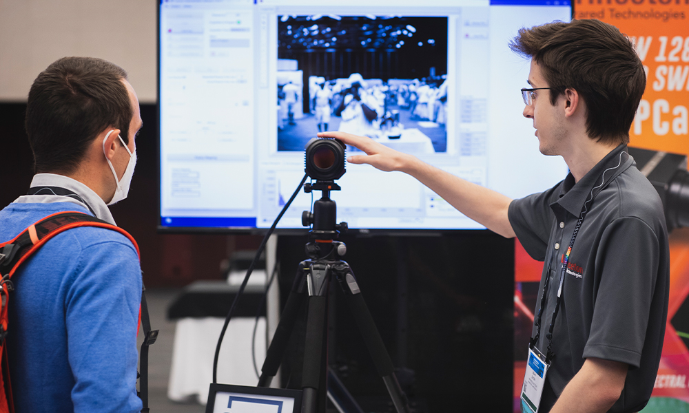 An exhibitor talks to an attendee at a conference.