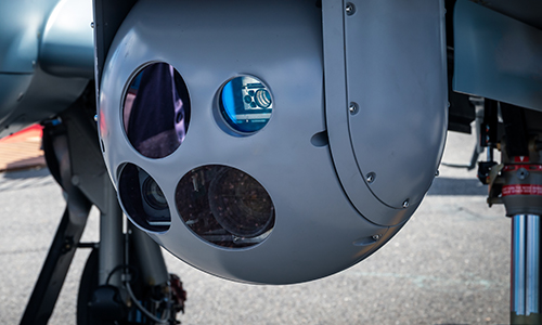 Close-up of a gray spherical camera system with multiple lenses mounted on an aircraft.