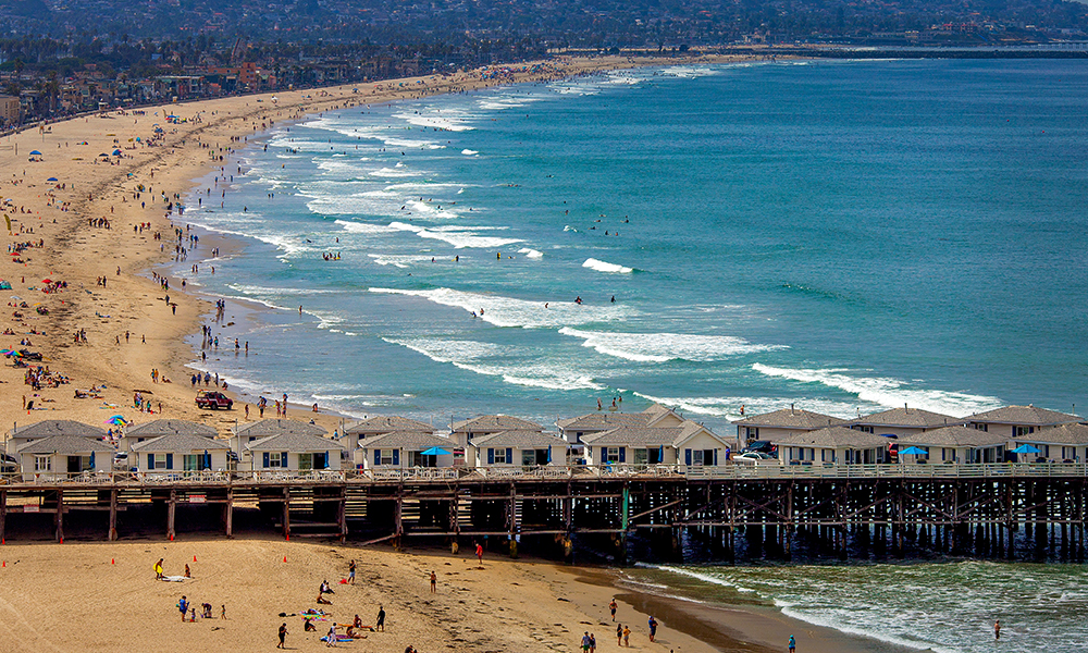 A sunny San Diego beach and boardwalk emphasizes the commitment to environmental sustainability