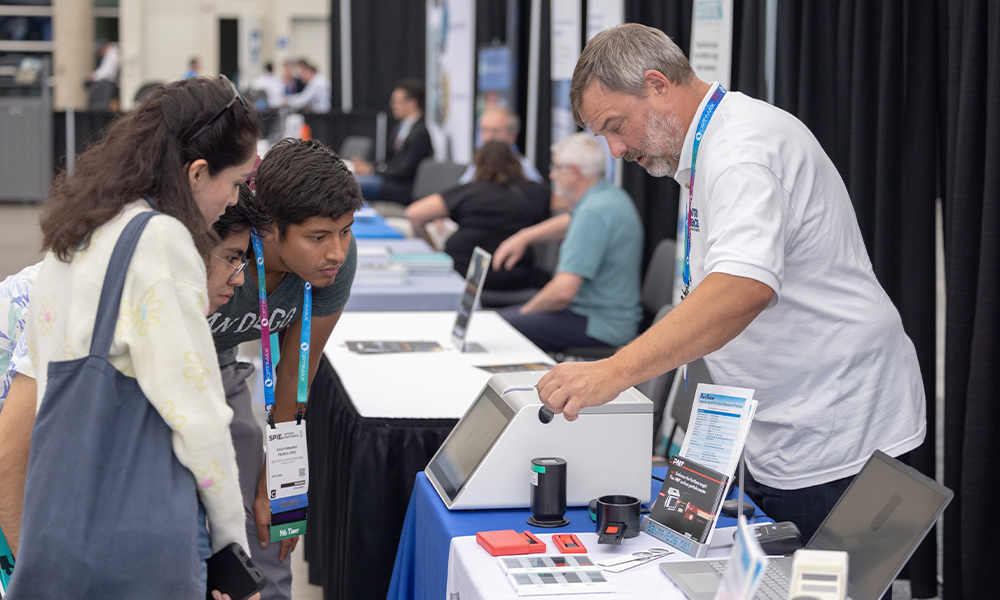 Exhibitor and attendees at SPIE Optics + Photonics exhibition