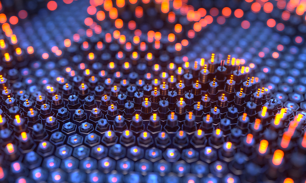 Nanophotonic surface with hexagonal lattice and orange light–emitting vertical elements against a dark metallic background.