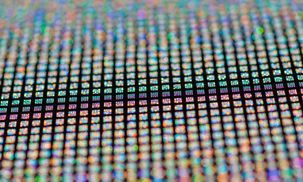 Abstract nanophotonic structure with glowing orange and blue elements arranged in a hexagonal pattern.