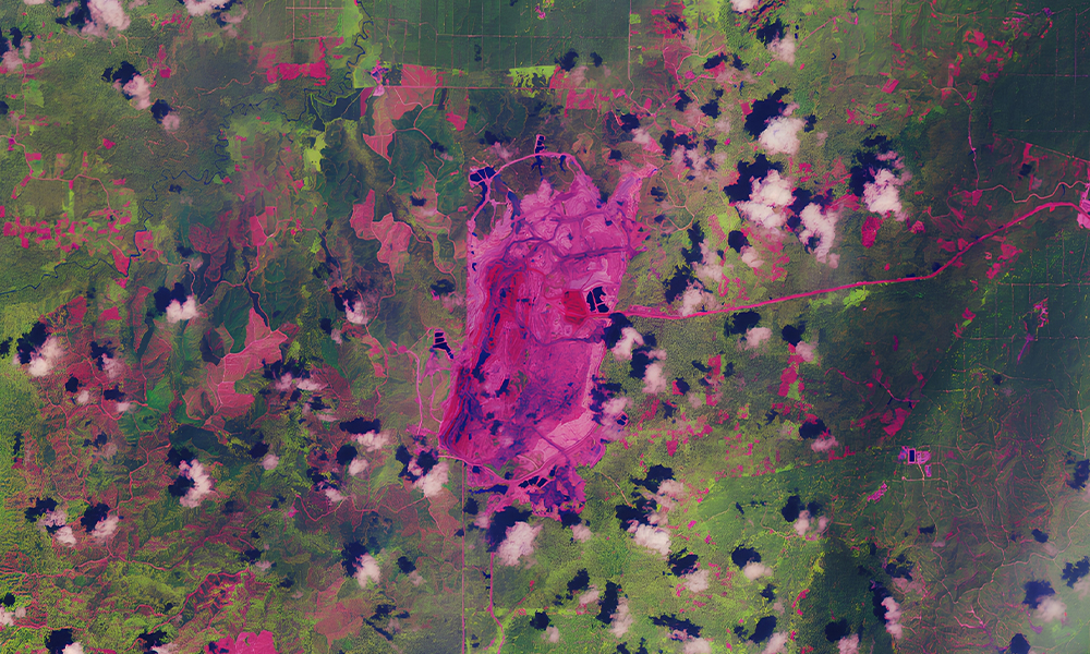 Satellite view using remote sensing over a large land area with clouds and vegetation.