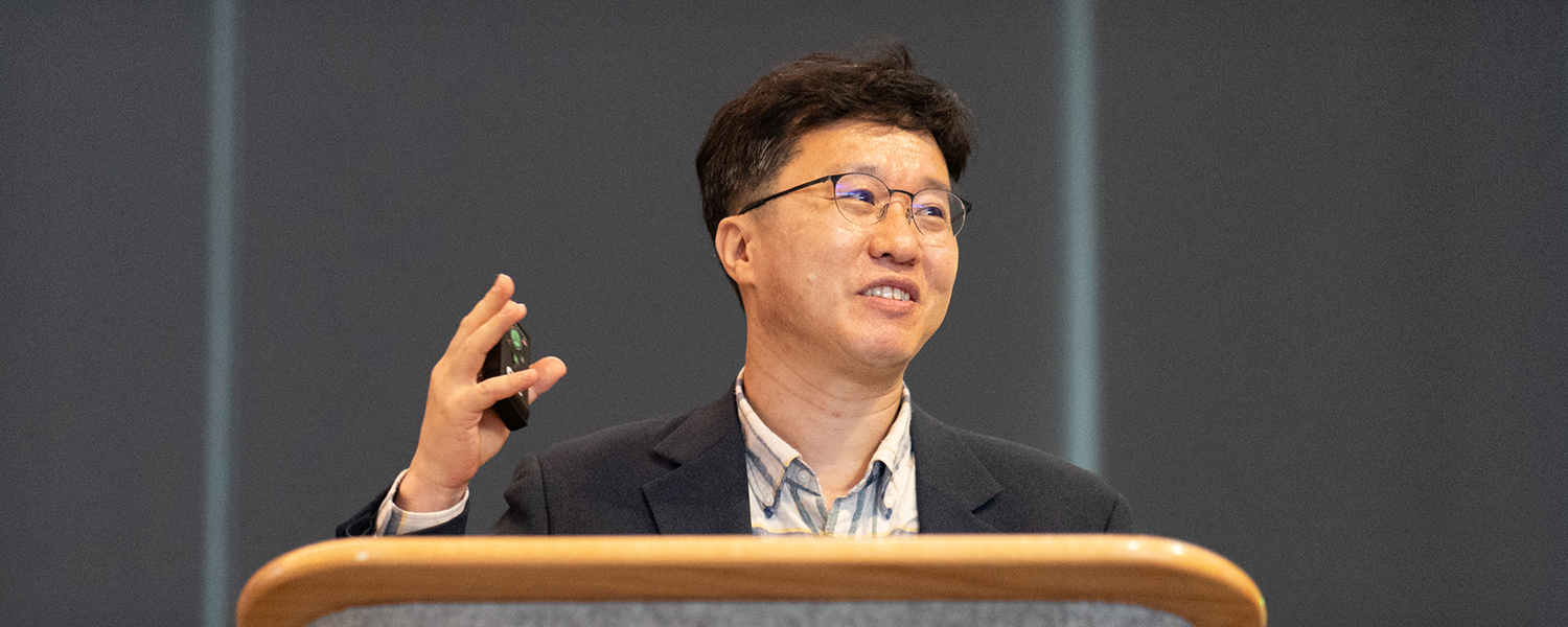 A male peaker addresses the audience from the podium for SPIE Advanced Lithography + Patterning