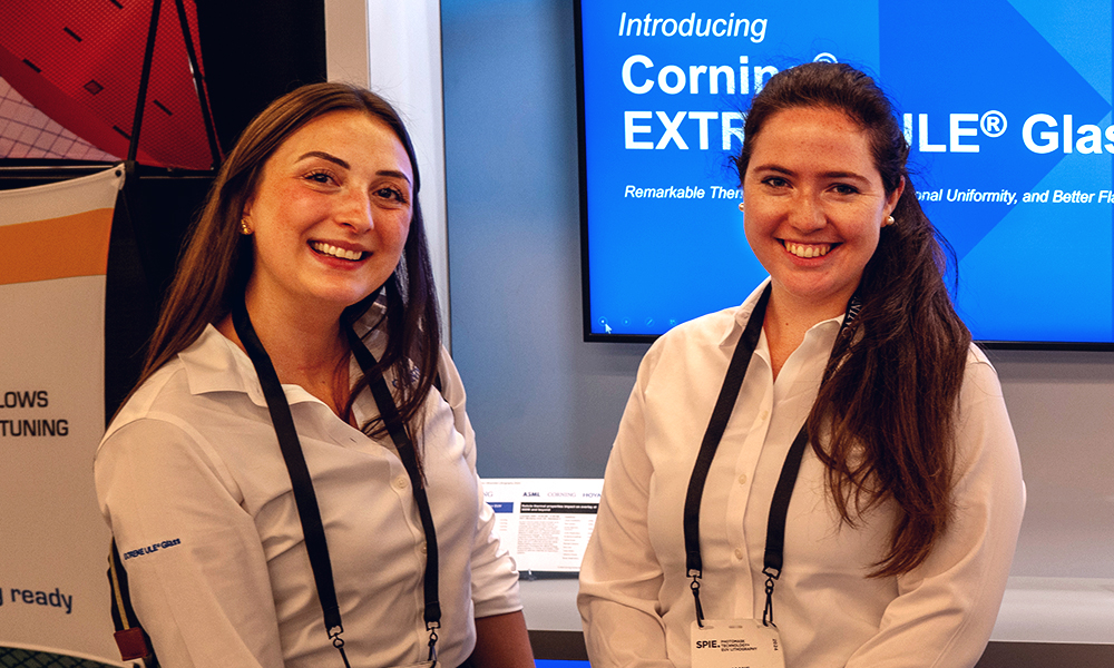 Two booth staff stand in their exhibit booth