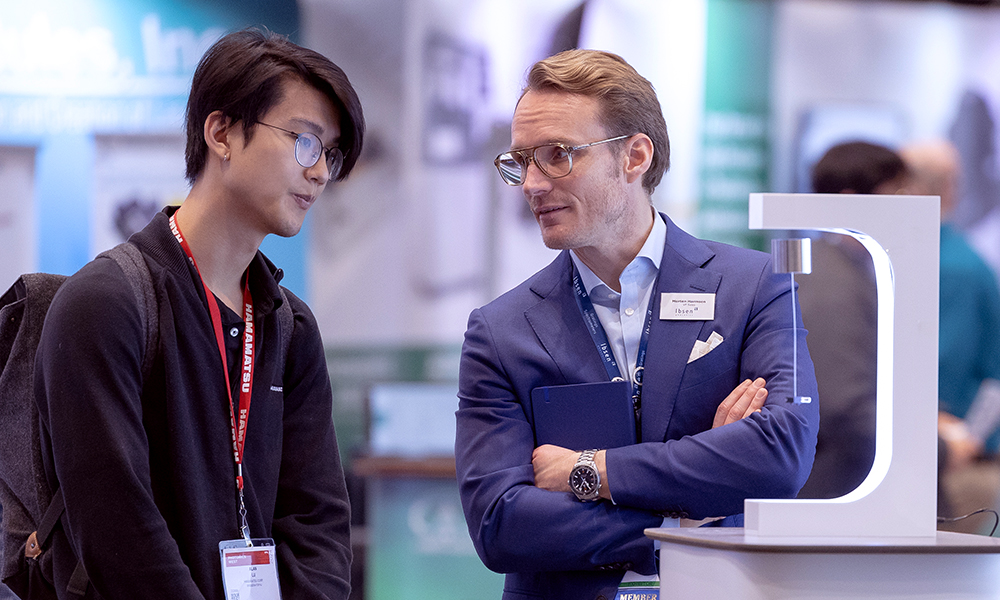 Two males discuss technology at SPIE Vision Tech Expo