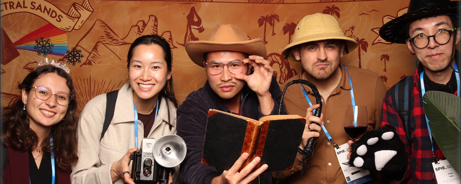 Five people pose in safari costume, while enjoying the Welcome Reception at Photonics West, themed "Into the Wild" in 2026.