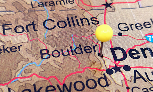 A closeup of a map with a pin dropped on Boulder, CO