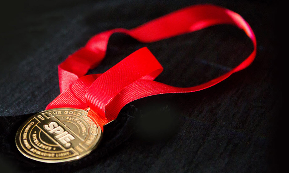 Gold medal on a red lanyard representing a SPIE Award