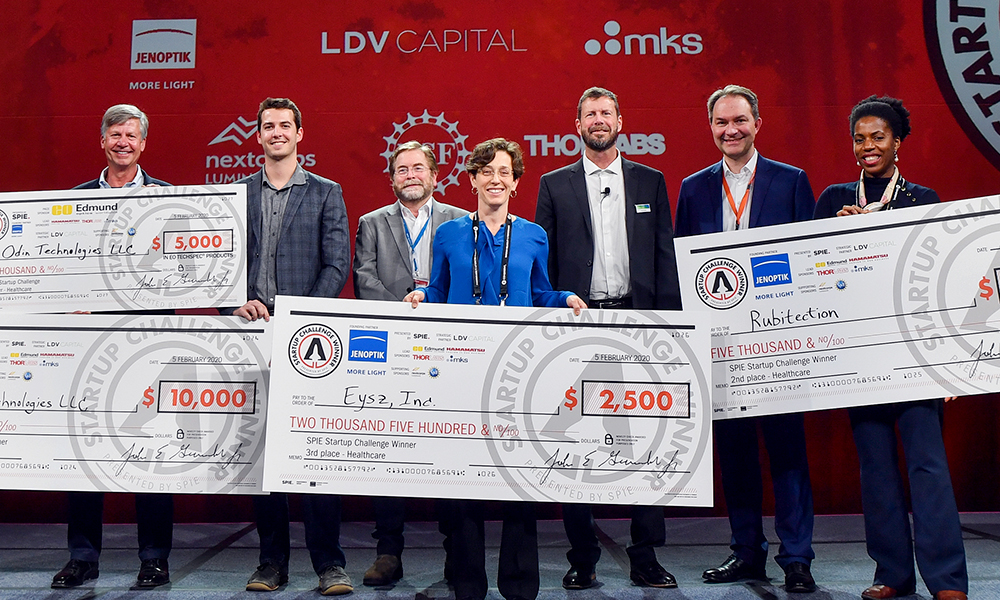Winners hold checks