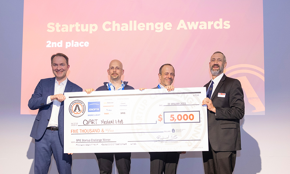 Four people holding a large check made out to "QART Medical Ltd." for $5,000, dated January 31, 2023, with "Startup Challenge Awards 2nd place" text in the background and logos for SPE and Repsol.