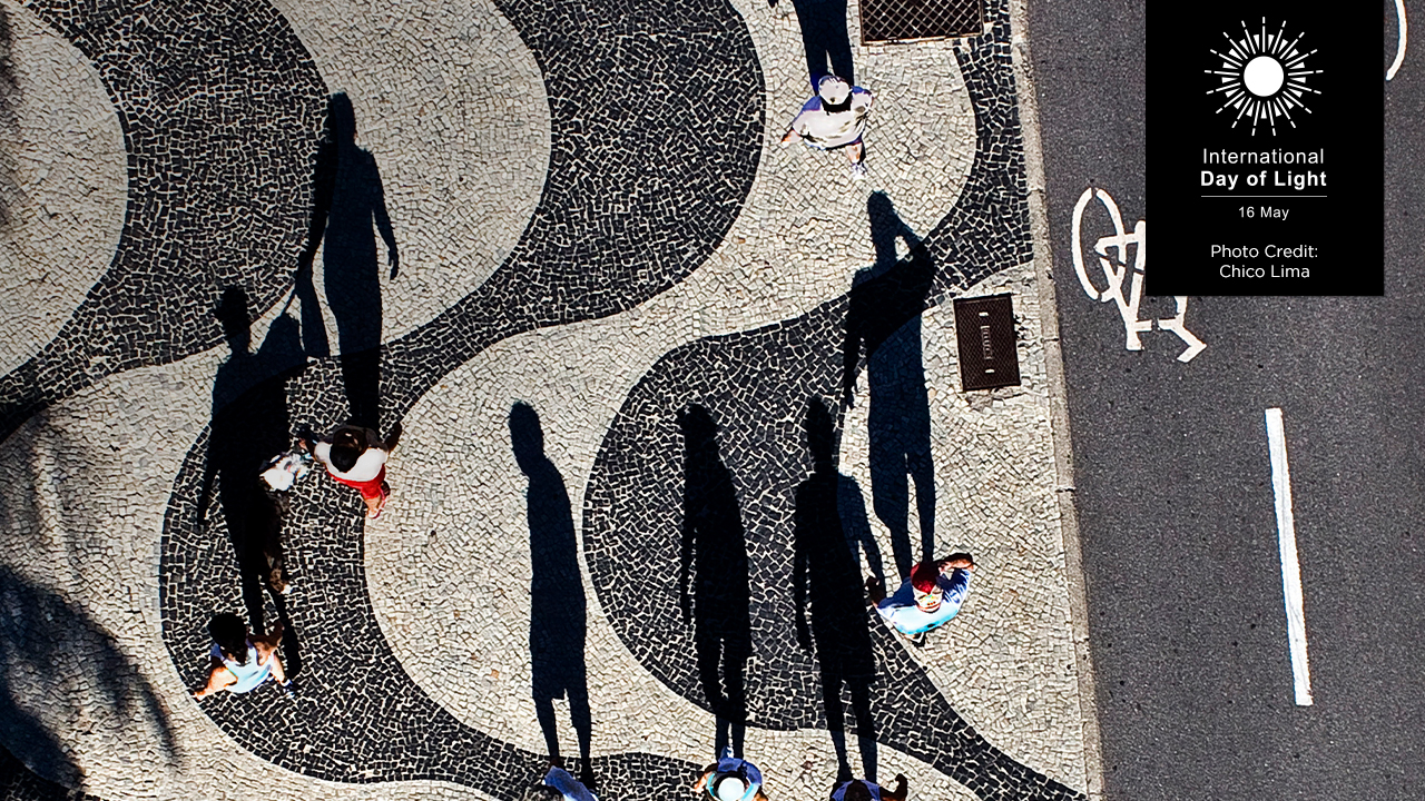 The second-place photo from the 2025 photo contest, which features people walking on a wavy black-and-white patterned sidewalk casting long shadows, viewed from above. Photo by Chico Lima.