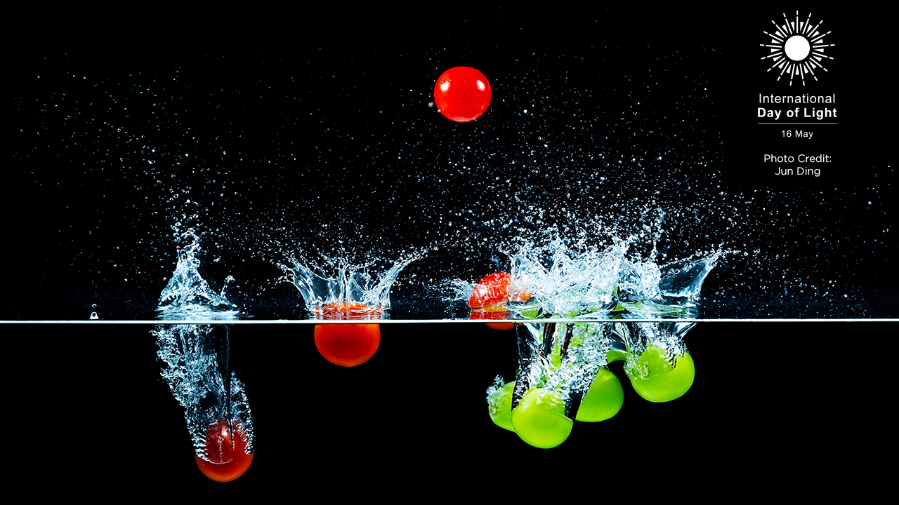 The second-place photo from the 2025 photo contest, which features red and green spheres of jade beads splashing into water against a black background, captured mid-motion. Photo by Jun Ding.