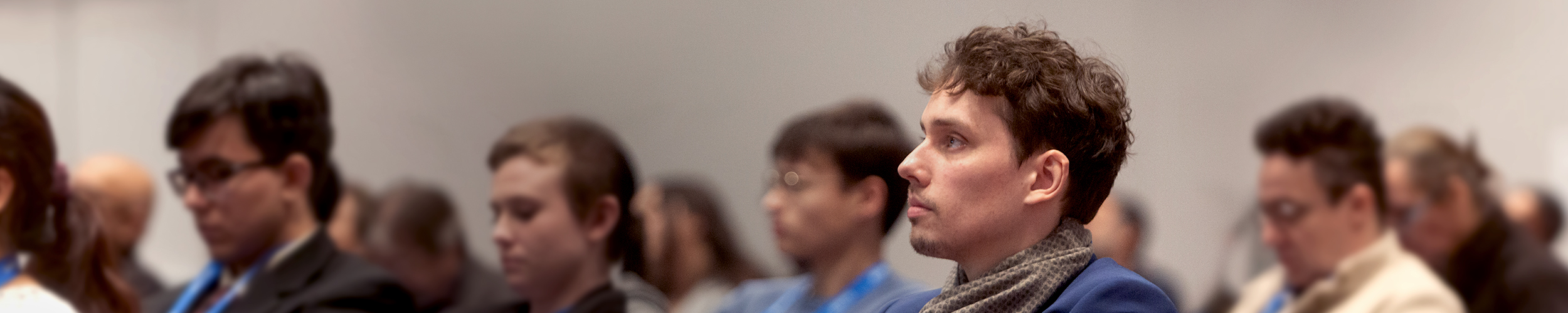 A group of attendees seated in a conference room, engaged in a course session.