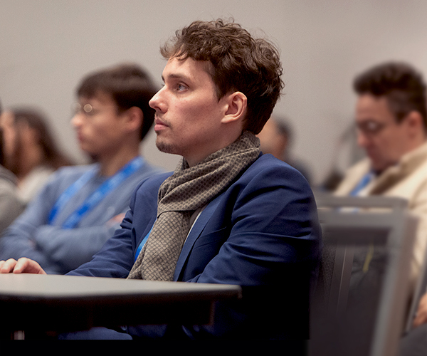 A group of attendees seated in a conference room, engaged in a course session.