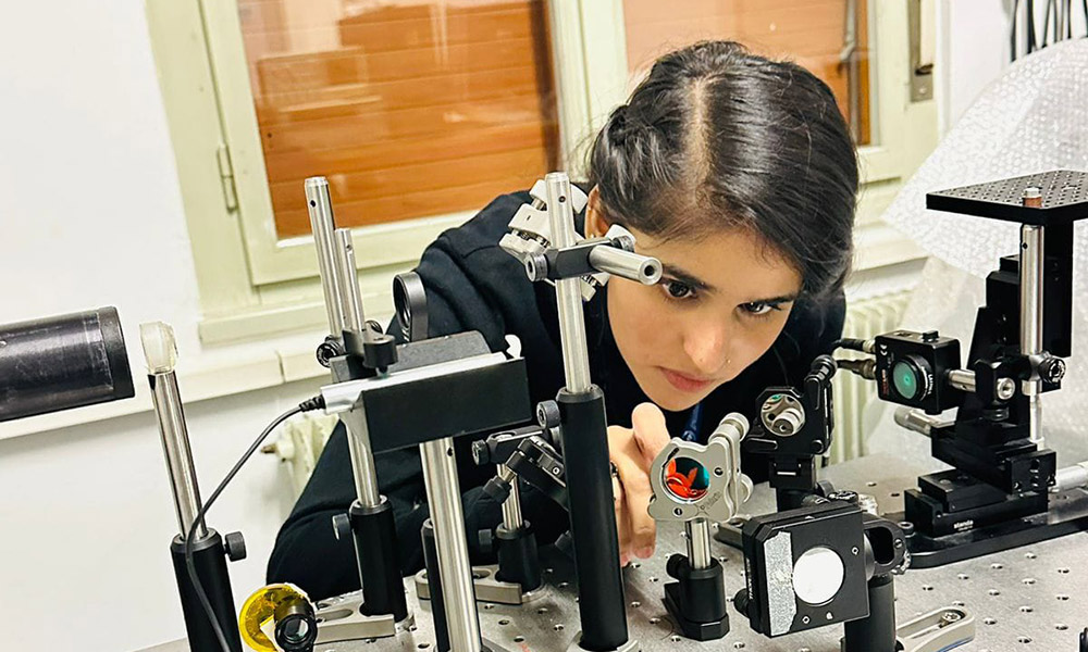 Isma Javed, in the ICTP's Mlab, aligning experimental photothermal spectroscopy technology.