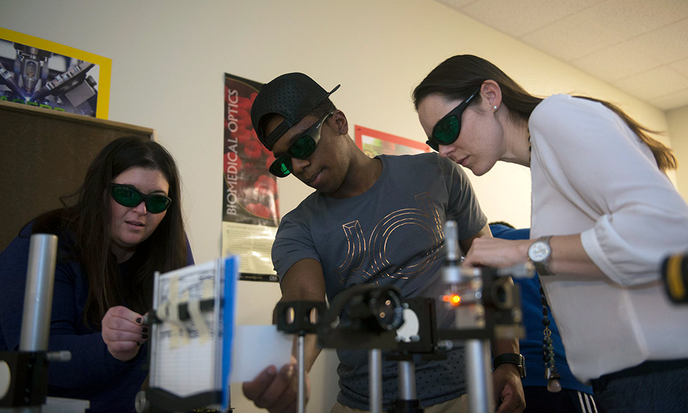 Alexis Vogt assisting students in a Geometrical Optics lab at Monroe Community College.
